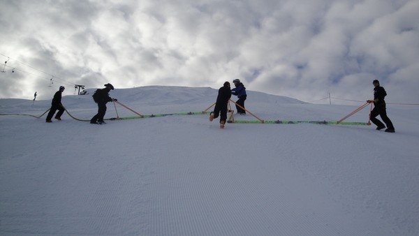 The Race and Events team work together with the snow injections as the clouds move in.